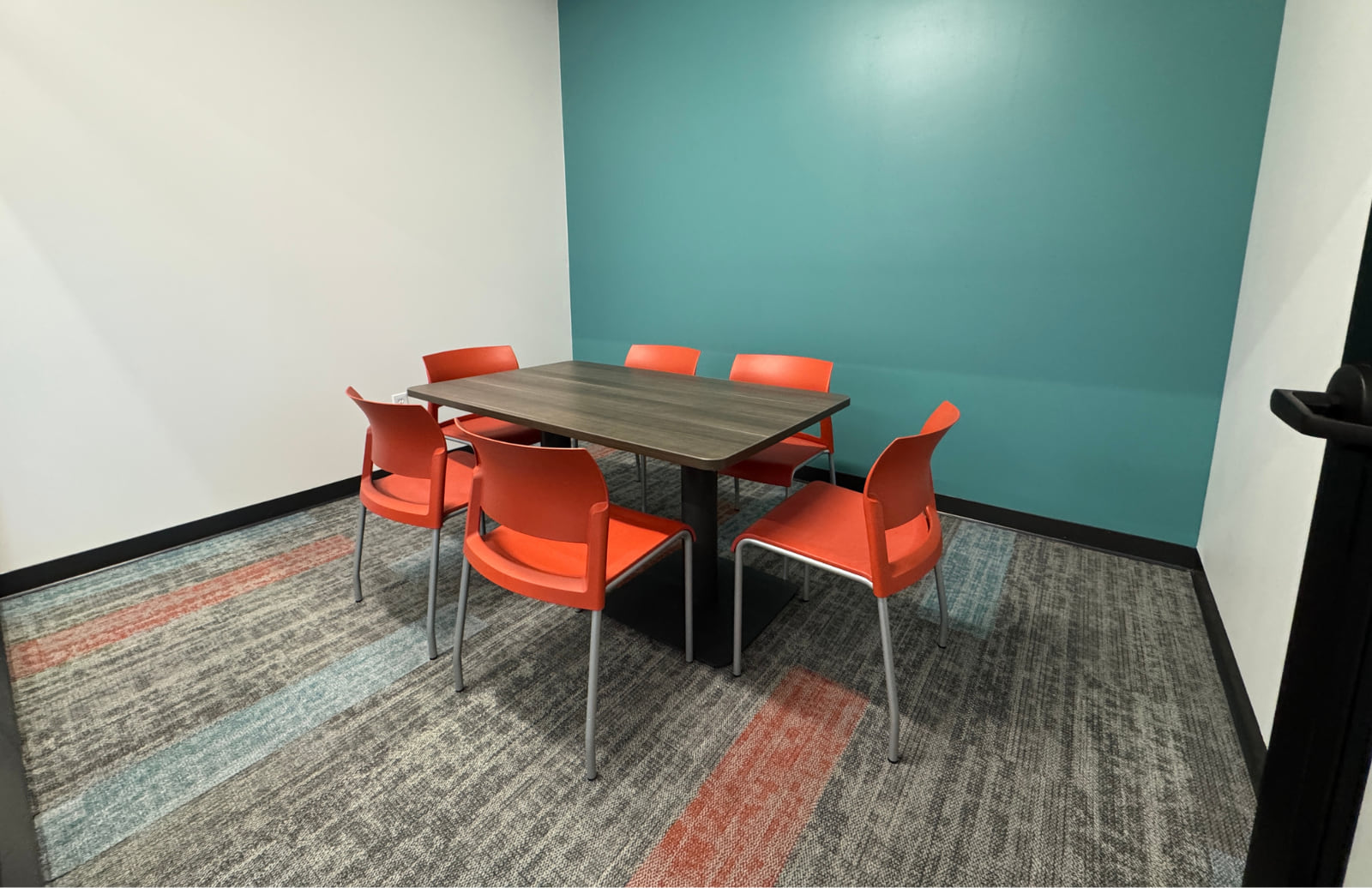 Interior of a study room with a desk and six chairs.
